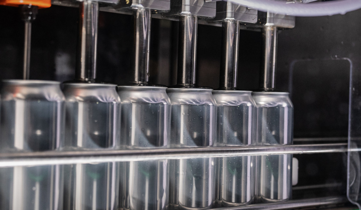 Cans in canning machine in Our Brewery