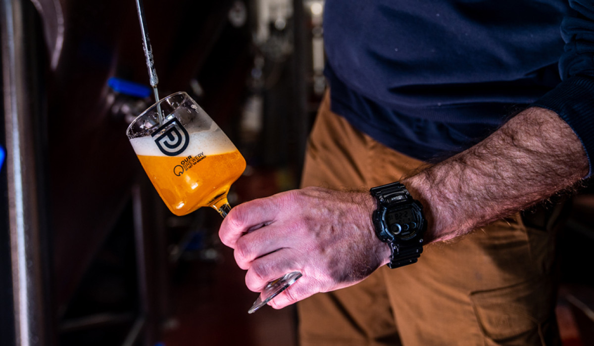 Pouring beer from the fermenter in Our Brewery